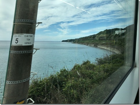 きのくに線車両内からの車窓。海沿いに曲がっていく。